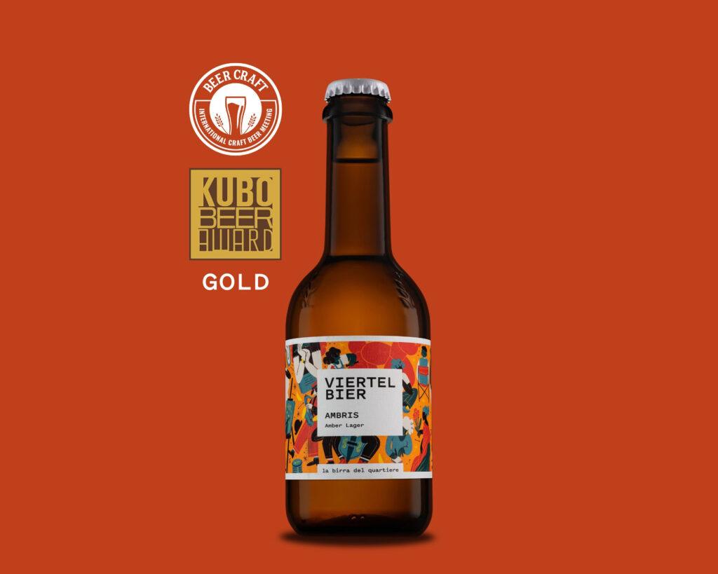 Das Foto zeigt die Flasche des Viertel Bier Ambris auf rotem Hintergrund. Daneben das Siegel des Kubo Beer Award Gold.